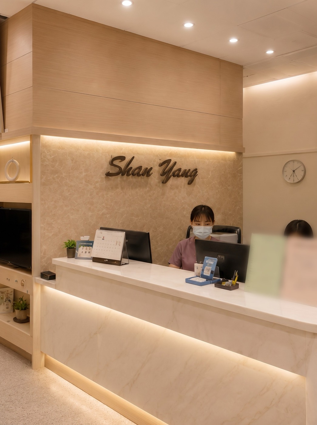 向陽牙醫接待櫃檯實景,溫暖的木質空間與 Shan Yang 招牌